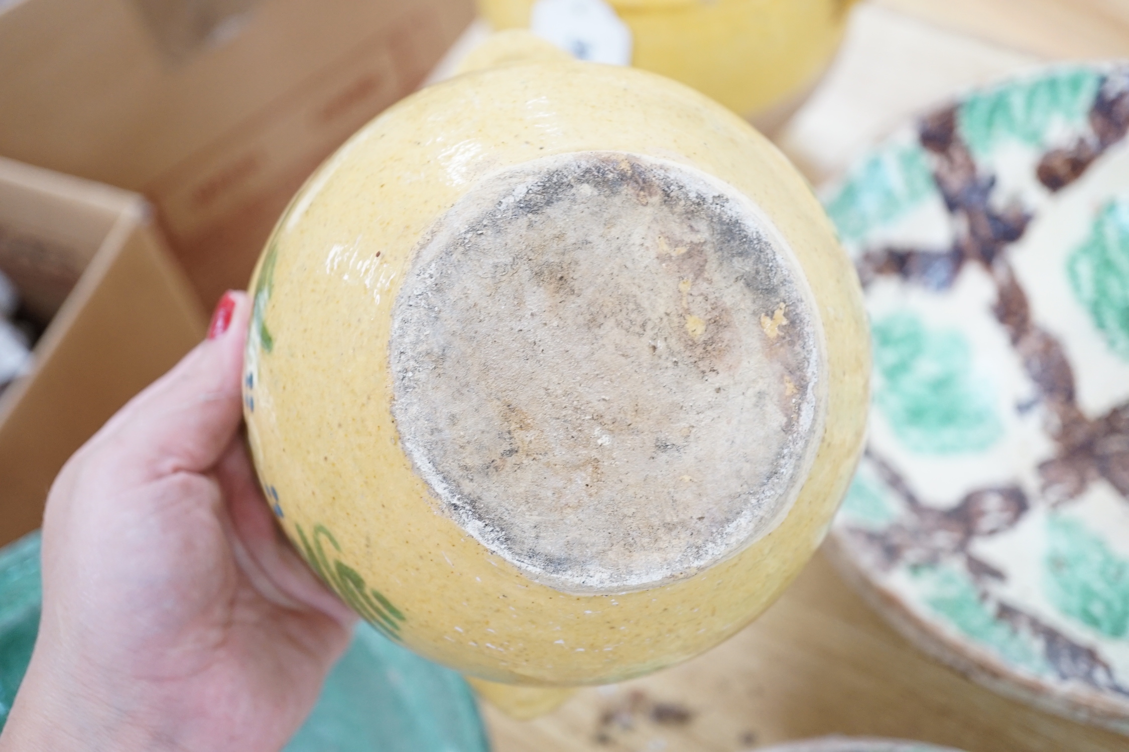 A group of Mediterranean slip decorated pottery dishes, a jar and cover and a bowl, predominantly with yellow and green grounds, the largest 26cm in diameter